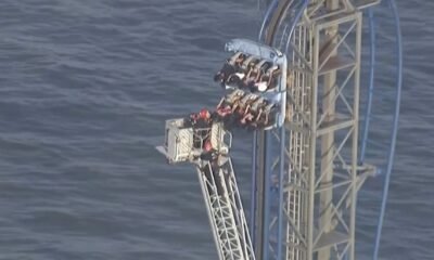 Firefighters work to free riders stuck atop a rollercoaster in Texas
