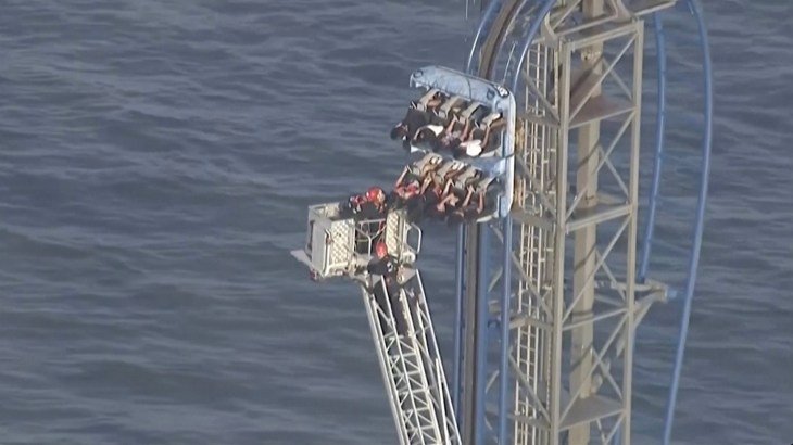 Firefighters work to free riders stuck atop a rollercoaster in Texas
